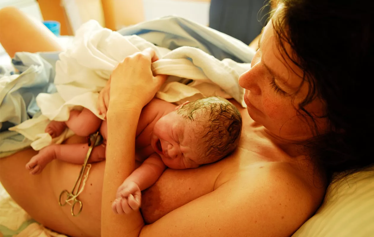 Synnyttänyt nainen vauvan kanssa sairaalan sängyssä