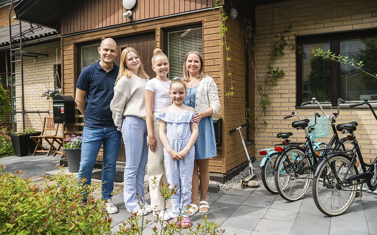 Remppa vai muutto -ohjelmassa kisaava Anna-Marian ja Tuomaksen perhe seisoo talonsa edustalla.