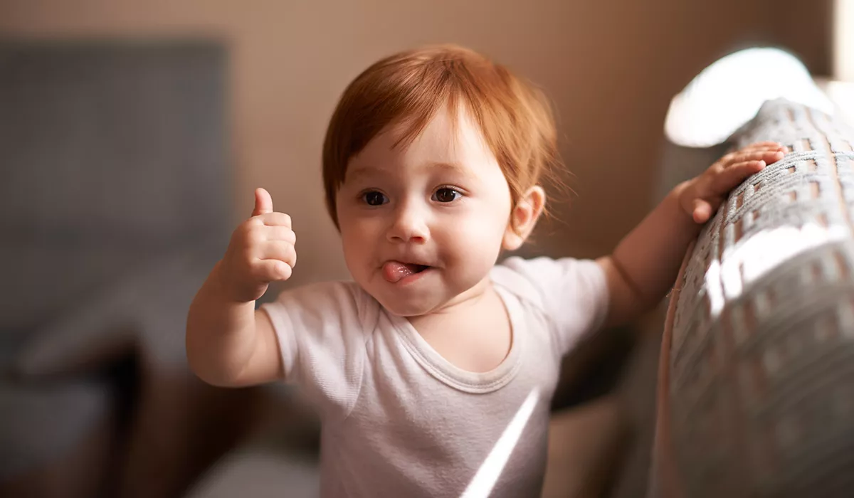vauvan aivojen kehitys: lapsi näyttää peukkua