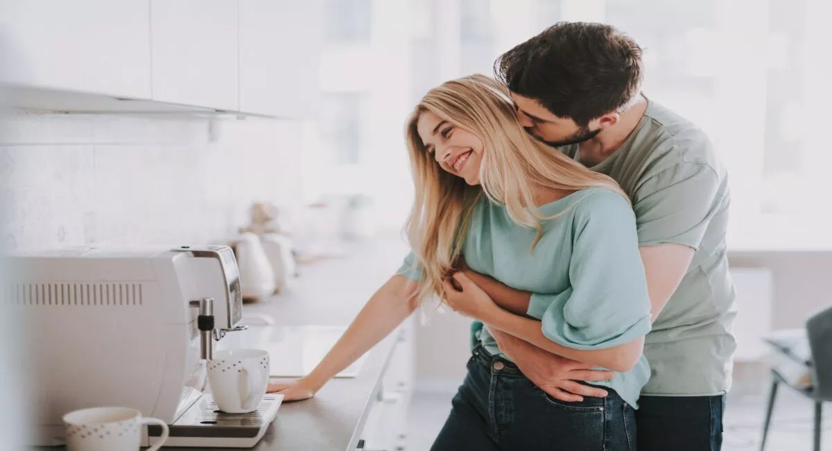 parisuhdeaika: pariskunta halaa keittiössä