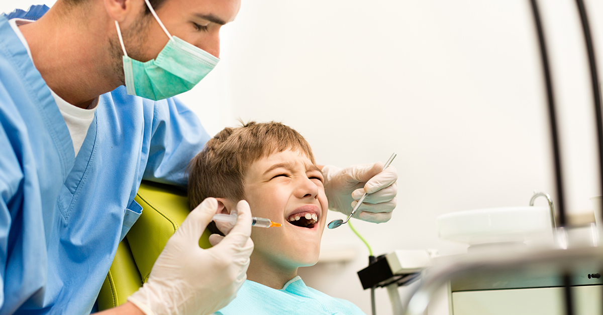 hammaslääkäripelko: hammaslääkäri tutkii lapsen suuta
