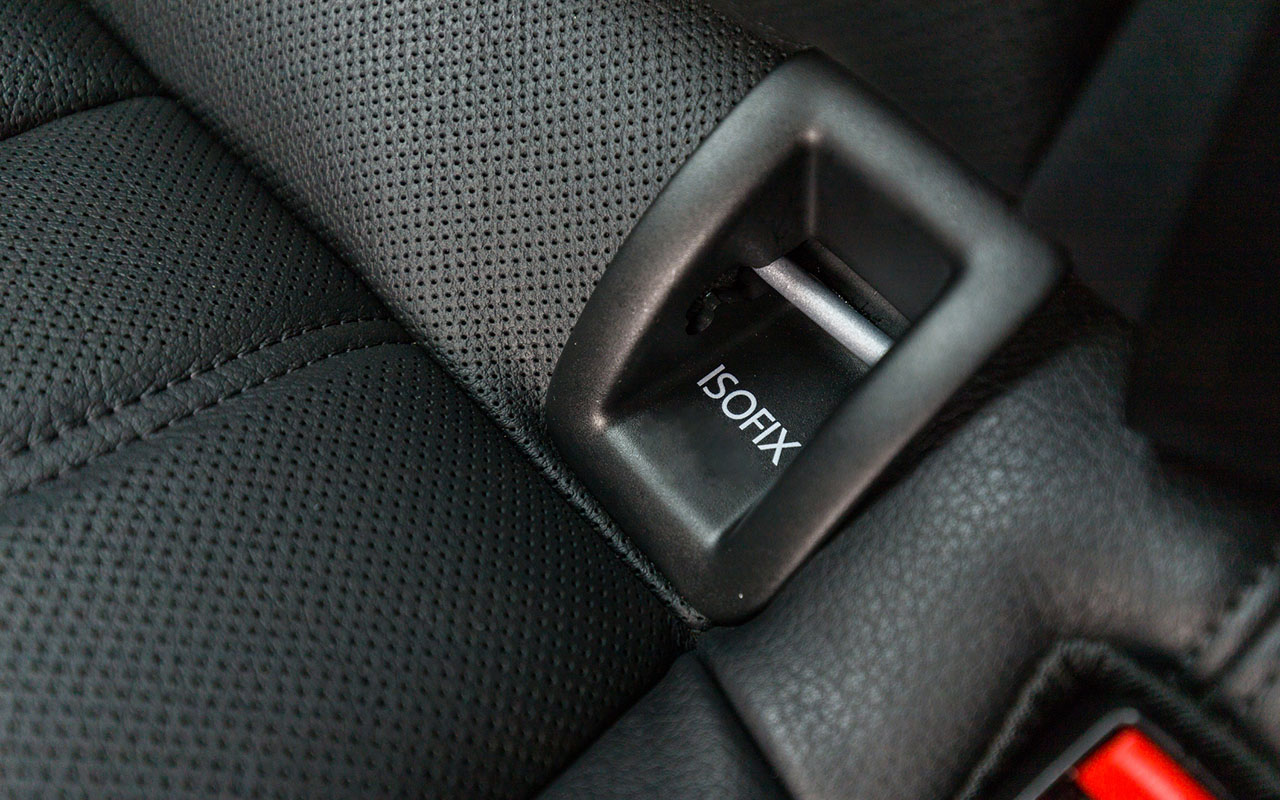 Kuvassa isofix, joka löytyy penkin ja selkänojan rajasta osassa autoista.