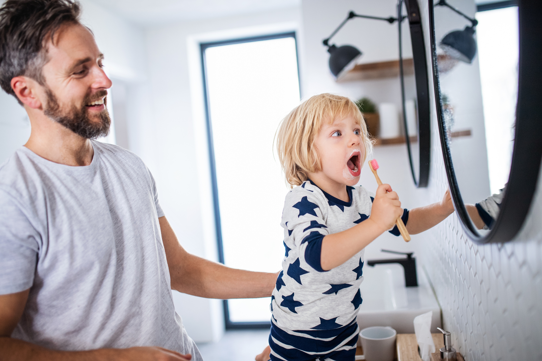 Lapsen hampaiden pesu voi myös helpottua peilin edessä. Kuvassa lapsi katselee itseään ihmetellen peilistä, kun harjaa hampaitaan.