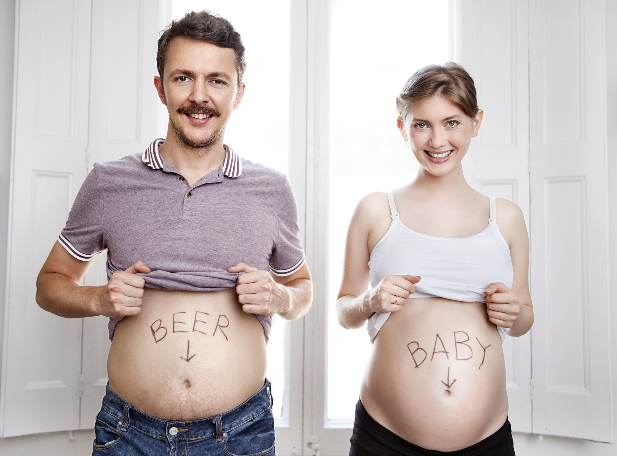 Hauskat raskauskuvat: Isän vatsassa lukee "beer" ja äidin "baby".