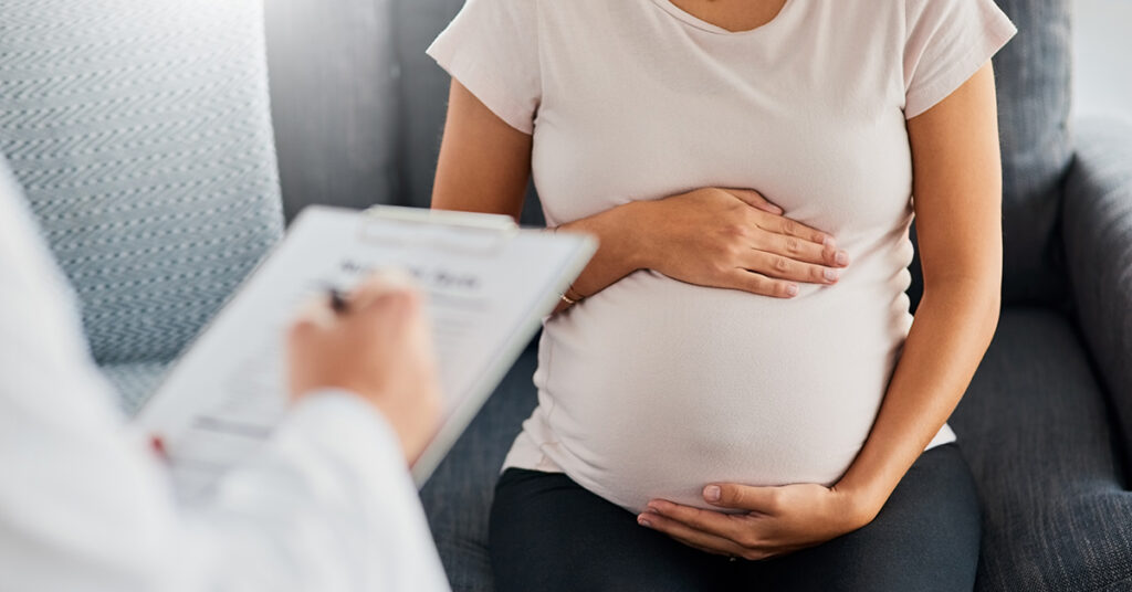yksityinen neuvola: raskaana oleva nainen pitelee vatsaansa