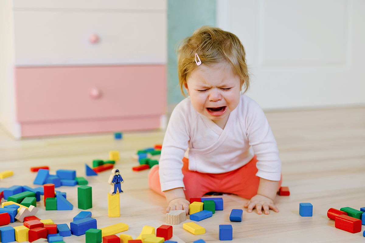Kiusaaminen päiväkodissa: lapsi itkee lattialla