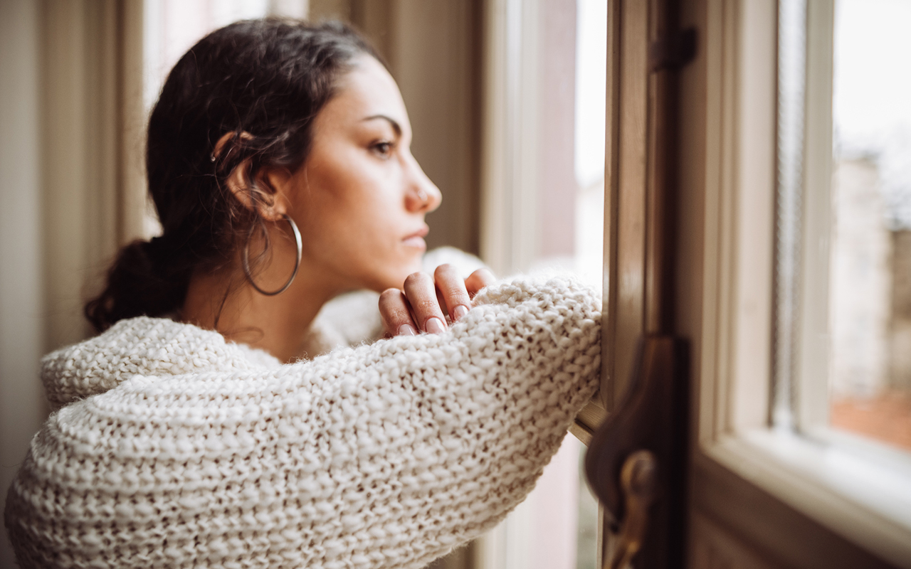 paniikkikohtaukset: nainen katselee huolestuneena ikkunasta.